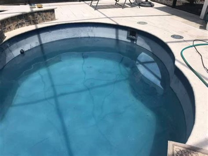 How do you remove white film from fiberglass pool?
